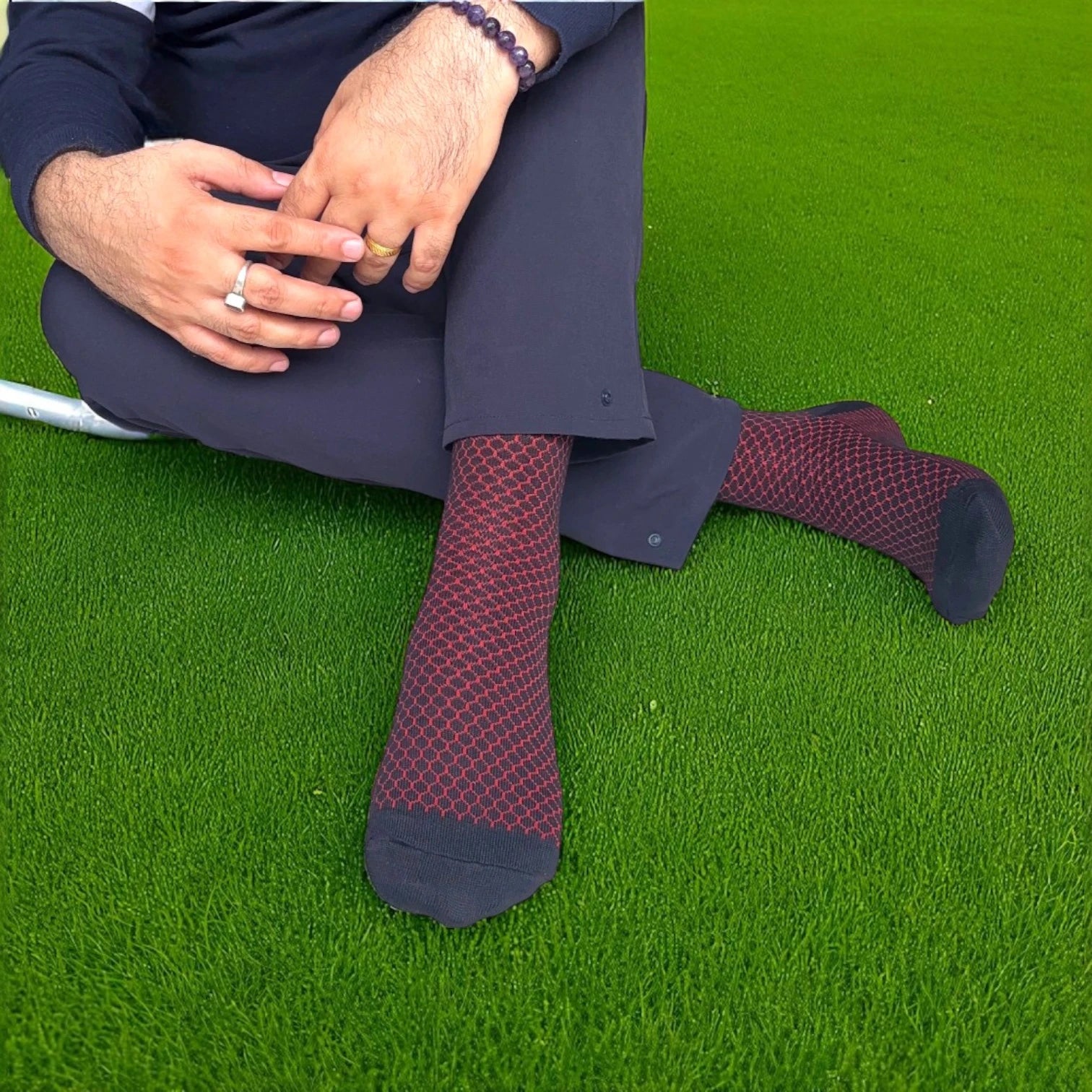 Person wearing dark purple patterned socks on a grassy surface